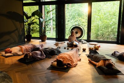 Deelnemers genieten van een soundhealing sessie met klankschalen en gong, omringd door een serene omgeving.